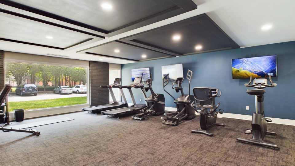 a gym room with treadmills, exercise equipment and television at The Edgewater