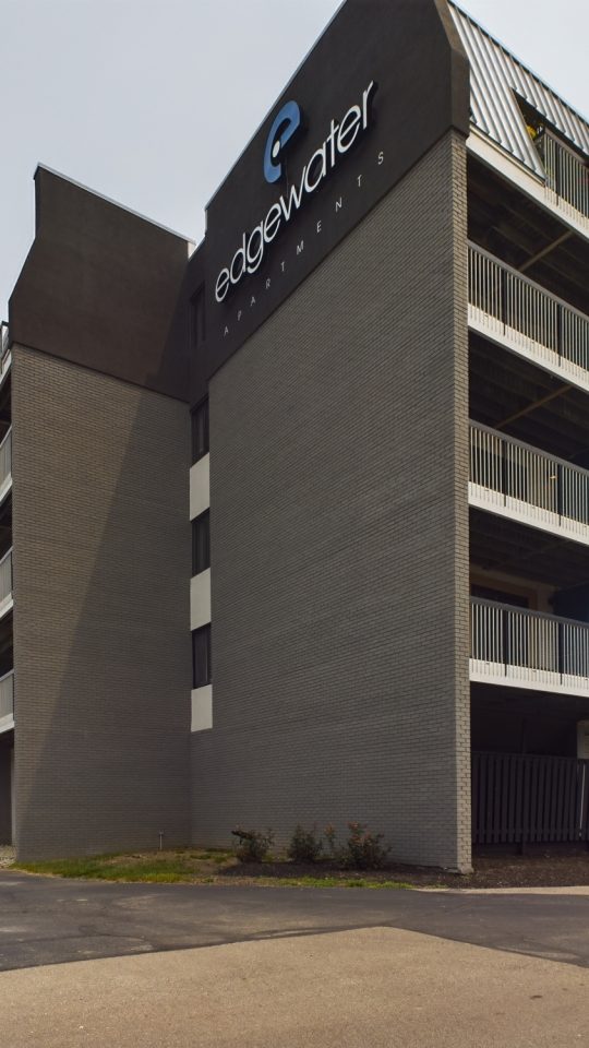 the parking lot of an apartment building with cars parked in front at The Edgewater